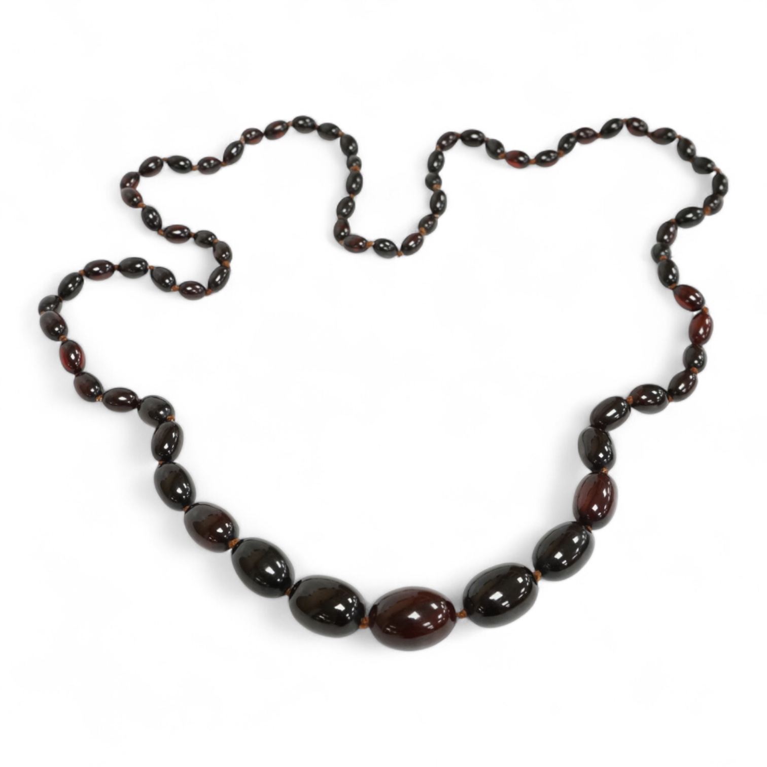 A single strand graduated simulated oval dark cherry amber bead necklace, 110cm, gross weight 90 grams.